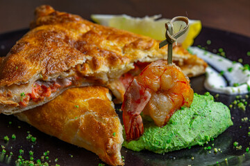 Salmon pie decorated with shrimp on a skewer