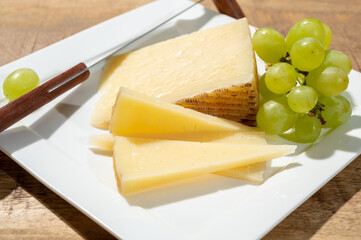 Cheese collection, piece of spanisch hard manchego cheese made in La Mancha region from sheep milk with green grapes