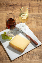 Cheese collection, piece of spanisch hard manchego cheese made in La Mancha region from sheep milk and glasses of sherry wine