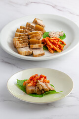 Bossam, boiled pork is eaten with spicy radish and Salted shrimp