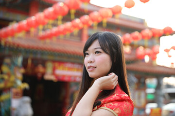 beauty woman wear red cheongsam looking and smile in chinese new year