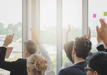 Multi ethnic diversity business audience group in seminar event raise hands up to asking question,...