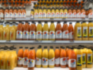 blurred background with juice bottles on shelves in a supermarket