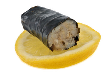 Feuille de vigne farcie coupée avec une rondelle de citron en gros plan sur fond blanc