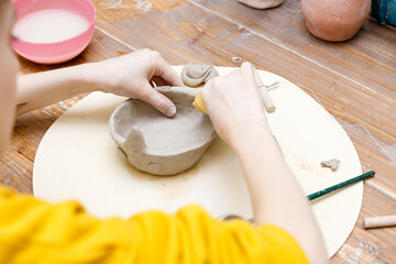 the child sculpts from clay
