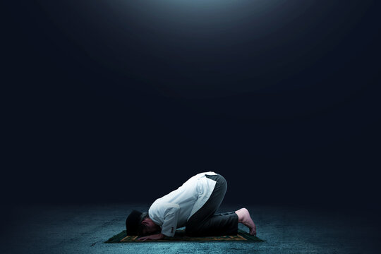 Asian Muslim Man In Praying Position (salat) On Prayer Rug