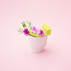 Pink and white flowers in white toilet. Pink background.