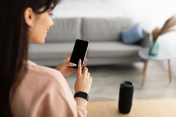 Back view of woman using phone with empty mockup screen