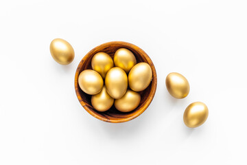 Golden eggs in wooden bowl. Wealth and good luck concept. Easter decoration