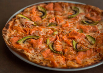 Pizza with salmon and avocado close-up