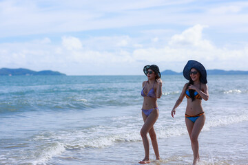 Two relaixng girl wear swimsuit on the beach.summer vacation concept