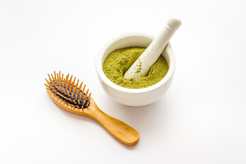 Henna hair dye powder and wooden comb. Henna in wtite mortar