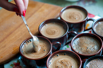 Brewing coffee in a cup on the table by the window