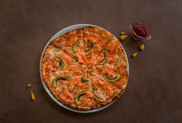 Pizza with salmon and avocado on a plate