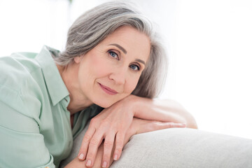 Photo of calm peaceful pretty retired pensioner woman lie hands sofa indoors inside house home apartment