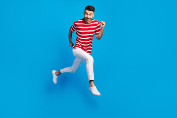 Fototapeta na wymiar Full body profile side photo of handsome excited happy man jump up run positive weekend isolated on blue color background