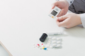 person measures blood sugar with glucometer