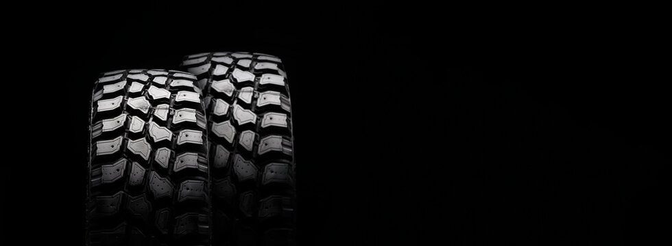 dirt tires for off-road driving on a black background. empty space copyspace, long layout