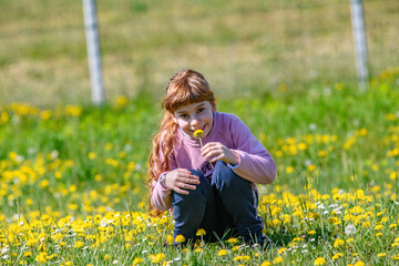 Bambina raccoglie tarassaco giallo, fiori gialli, con sorriso e divertimento