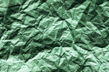 green crumpled paper texture background. shadows and huts resemble the surface of an unknown planet, a picture from space