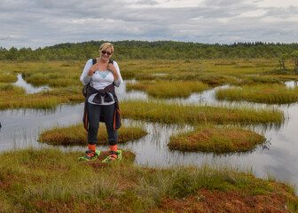 summer landscape from the swamp, happy woman with snowshoes in the swamp, walk on the marsh, bog dating, wild