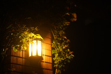 a lamp on the wall of a church in the night