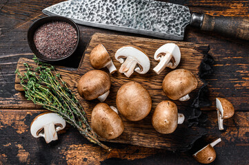 Cut Raw Royal brown champignon mushrooms. Dark wooden background. Top view