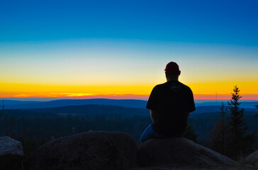 Man watching the sunset in the mountains