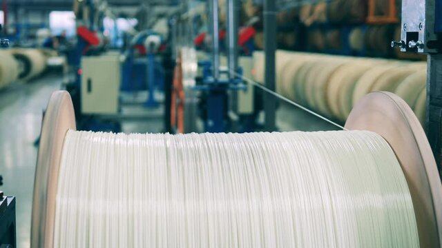 White power cable unwinding from a huge spool