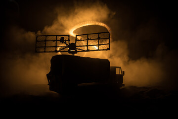 Creative artwork decoration. Silhouette of mobile air defence truck with radar antenna during...