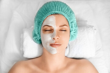 A beautician applies a mask to the face in a beauty salon. The concept of facial hygiene, cosmetic...