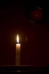 candle in the dark with electrical lamp