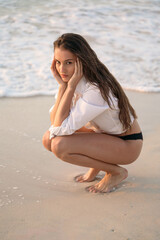 Fototapeta na wymiar Young beautiful woman sitting on the beach
