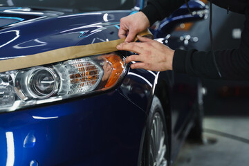 Man prepares car headlights for polishing..