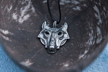 Pendant wolf head necklace silver color stainless steel shoot outside in a summer day closeup. Selective Focus. High quality photo