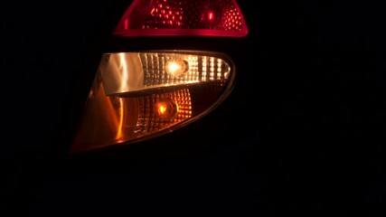 Car taillight at night. Flashing turn signal.