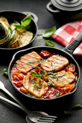 Grilled halloumi cheese and tomato bake served in cast iron skillet, close-up. Delicious vegetarian food. 