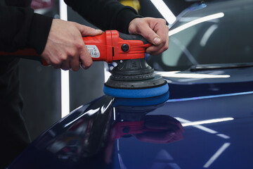 Man in a mask polishes car