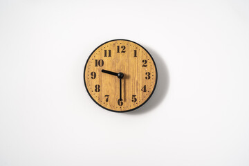 wood office wall clock with white dial on white background. wall clock on white background, top view.