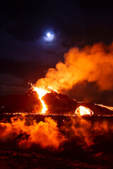 Moon over erupting volcano in Geldingadal Iceland