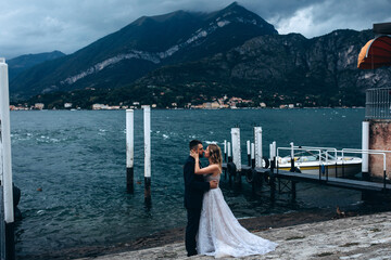 A romantic walk for the bride and groom along the shores of an Italian lake. It's a nasty day.