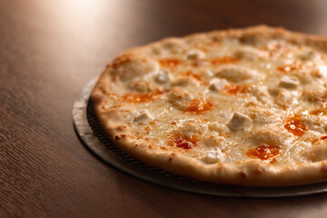 Cheese pizza on a baking grid on the table