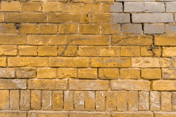 Old brick yellow wall as background. Backdrop of a contemporary stacked stone wall in warm brown tones