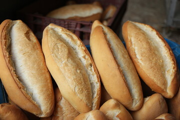 Traditional crusty French bread baguette in basket at bakery.