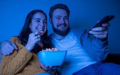 Attractive young couple watching television
