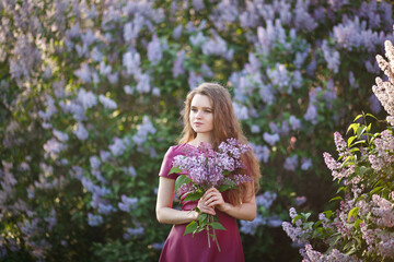 beautiful girl in a short purple dress walks in the lilac garden, leather dress, lilac bloom