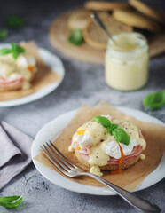 Egg benedict sandwiches - muffin with poached egg, ham and hollandaise sauce