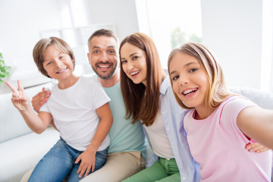 Photo portrait of friendly family taking selfie sitting together smiling little son showing v-sign gesture wearing casual clothes