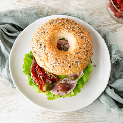 bagel with ham, capers and sun-dried tomatoes, top view