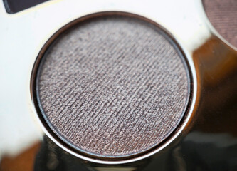 A close-up of pearlescent shimmery gold eyeshadow for creating eye makeup.  Beauty concept.